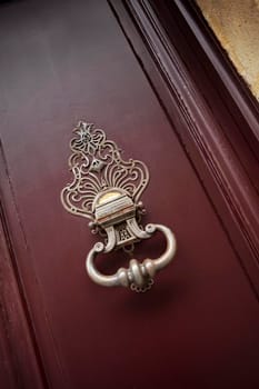 Detail of an old bronze knocker on the door of a French mansion
