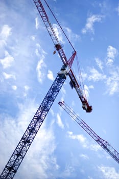Crane on a construction site and cloudy blue sky