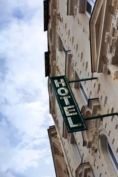 Neon sign and stoned facade of an old French hotel