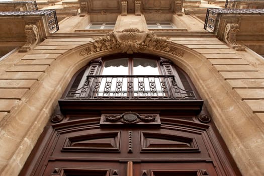 Wooden door and stoned facade of a French mansion