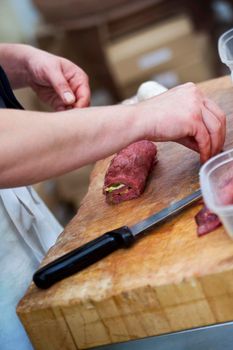 Butcher preparing a roast veal with cheese