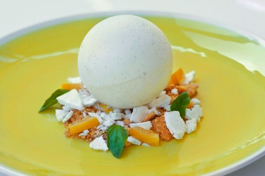 Dessert with vanilla ice cream, lemon, biscuit, basil and meringue