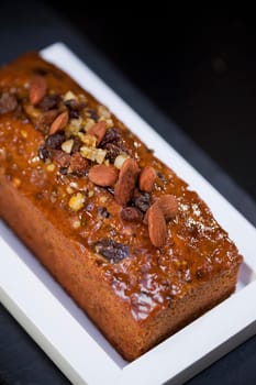 Cake with dried fruits and almonds on a dish