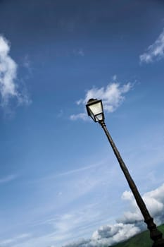 Vintage street lamp, mountains and cloudy sky in French Pyrenees