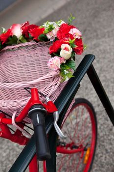 Flowers and wicker basket on a bike parked on the street