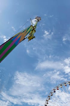 Ride and big wheel at a fairground in Summer