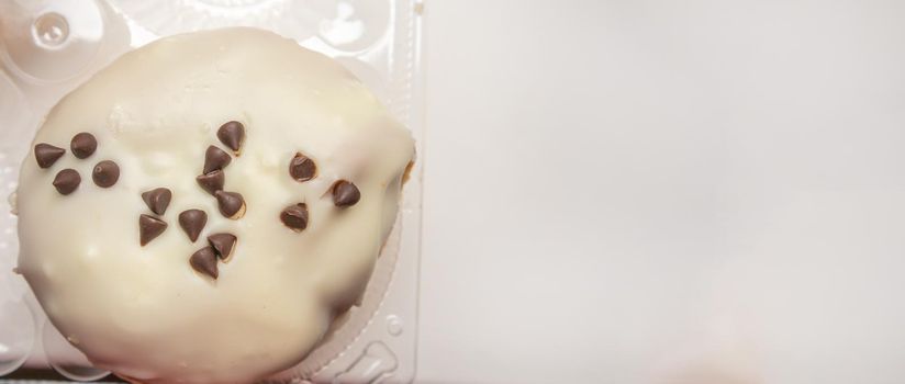 Delicious donut with icing sugar and chocolate chips top view, banner with a copy of the space on the right.