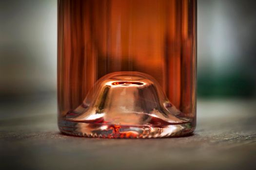 Macro of a glass bottle of rose wine in a French pub