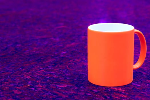 a small bowl-shaped container for drinking from, typically having a handle. Red ceramic cup mug on dark red blue spotted background