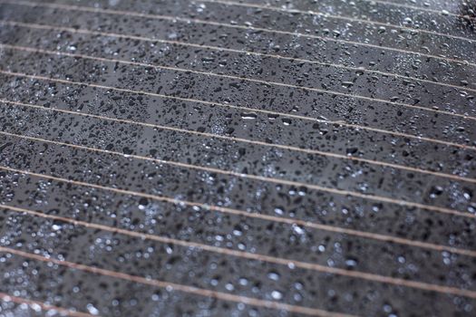 Drops of water on rear car window, heating stripes visible.
