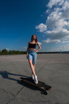 Young caucasian woman riding a longboard outdoors