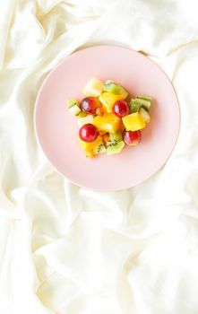 juicy fruit salad on silk, flatlay - healthy lifestyle and breakfast in bed styled concept