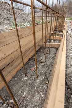 Close-up of the reinforcement of a shallowly buried strip foundation of a low-rise residential building a