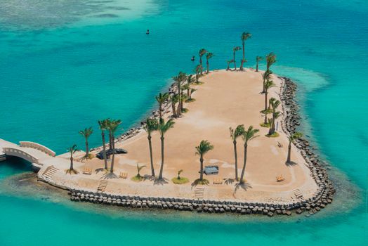 Aerial view over small island in tropical sea with palm trees and landscape view of coastline