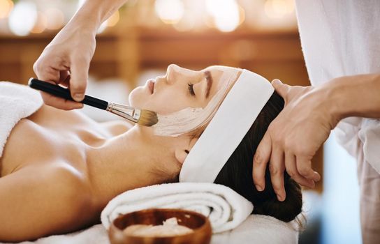Time for a bit of a beauty booster. an attractive young woman getting a facial at a beauty spa