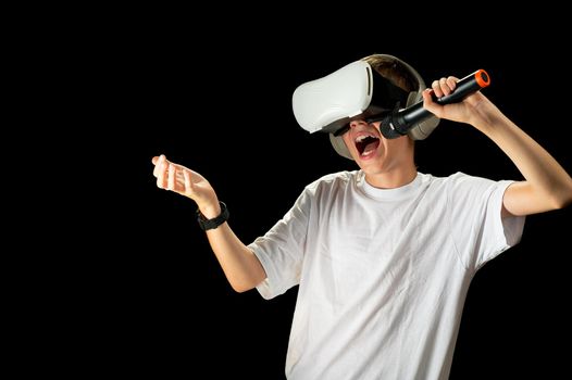 Teenager use modern technologies for entertainment or education. Kid in VR glasses, black background. Childrens in VR glasses singing with microphone. virtual Karaoke VR musician concept.