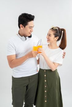 A healthy young asian couple drinking orange juice