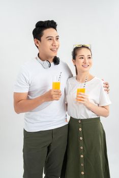 A young pretty Asian couple with a glasses of Orange juice