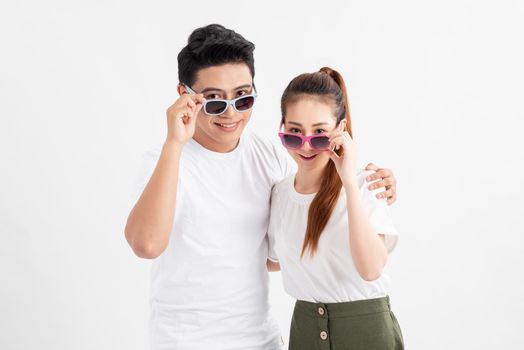 Funny couple in casual style clothes and color glasses looking at camera.