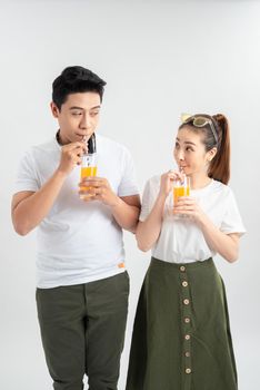 A young pretty Asian couple with a glasses of Orange juice