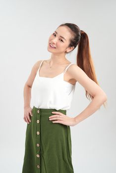 Happy young Asian woman standing over white background.