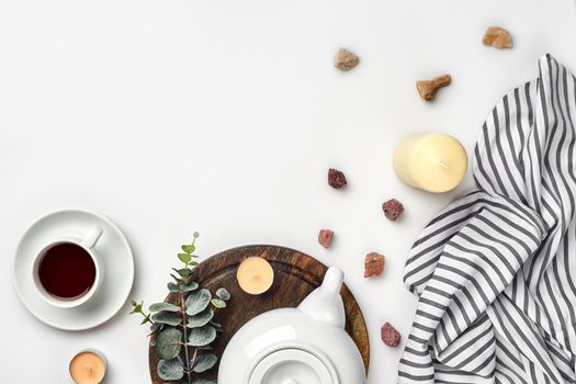 Still life with tea cup and the contents of a workspace composed. Different objects on white table. Flat lay. Top view. Copy space