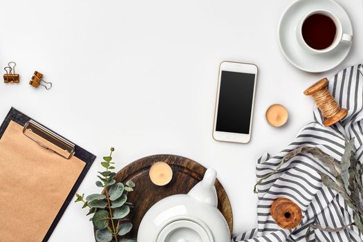 Still life with tea cup and the contents of a workspace composed. Different objects on white table. Flat lay. Top view. Copy space