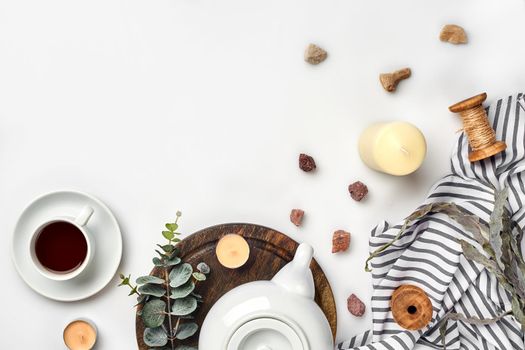 Still life with tea cup and the contents of a workspace composed. Different objects on white table. Flat lay. Top view. Copy space