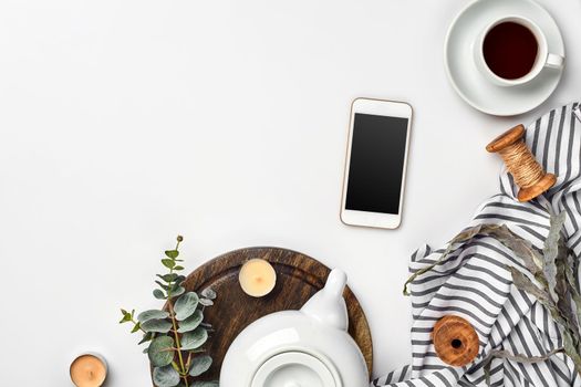 Still life with tea cup and the contents of a workspace composed. Different objects on white table. Flat lay. Top view. Copy space