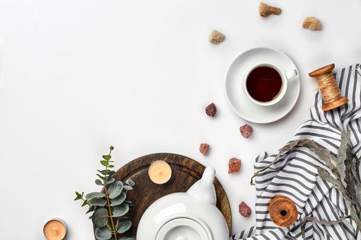 Still life with tea cup and the contents of a workspace composed. Different objects on white table. Flat lay. Top view. Copy space