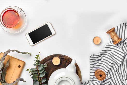 Still life with tea cup and the contents of a workspace composed. Different objects on white table. Flat lay. Top view. Copy space