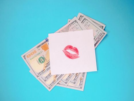 Dollars, white paper with red lips print. Banknotes on a blue background. Love for money.