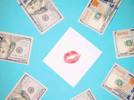 Dollars, white paper with red lips print. Banknotes on a blue background. Love for money.