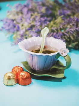 Handmade beautiful flower cup of fragrant tea violet porcelain and candies