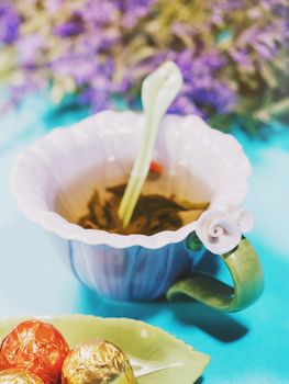 Handmade beautiful flower cup of fragrant tea violet porcelain and candies