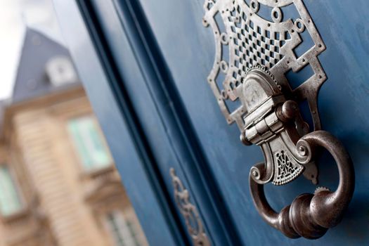 Close up of a weathered knocker on a wooden door