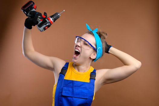 Female construction worker yawns with a tool in her hands, studio shot.