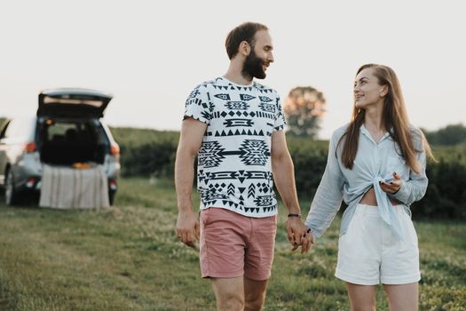 Middle-aged couple enjoying road trip, caucasian man and woman walking outdoors in nature outside the city