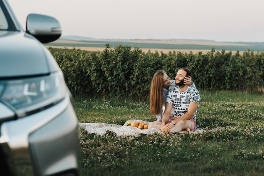 Happy middle-aged couple having picnic outside the city, cheerful man and caucasian woman enjoying weekend together on road trip