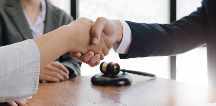 Businessman shaking hands to seal a deal with his partner lawyers or attorneys discussing a contract agreement..