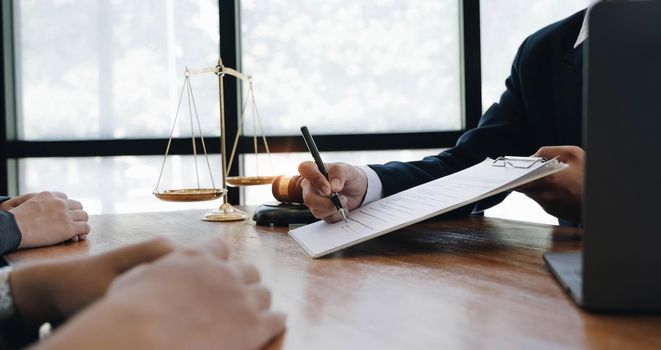 Business woman and lawyers discussing contract papers with brass scale on wooden desk in office. Law, legal services, advice, Justice concept..