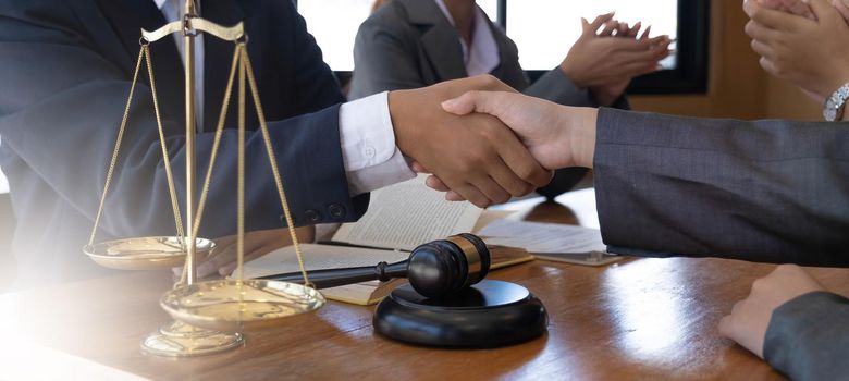 Businessman shaking hands to seal a deal with his partner lawyers or attorneys discussing a contract agreement..