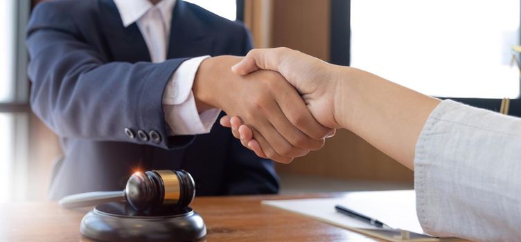 Businessman shaking hands to seal a deal with his partner lawyers or attorneys discussing a contract agreement.