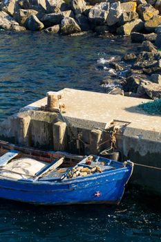Old blue wooden boat moored at the pier top view on a sunny day