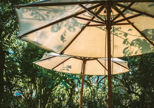 Sunlight through white parasol umbellar. Garden furniture function design decoration.