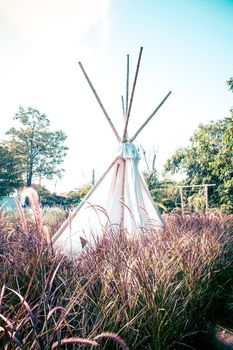 Outdoors area decorated in a Bohemian style with a white tent