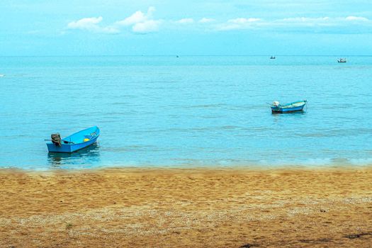 Small fishing boat floating in blue sea with blue sky, Thailand Fishing boat or fisherman boat or ship on Sam Roi Yod bech Prachuap Khiri Khan Thailand with blue sky and cloud and blue sea.