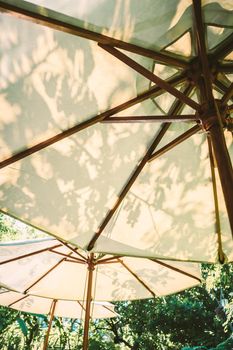 Sunlight through white parasol umbellar. Garden furniture function design decoration.