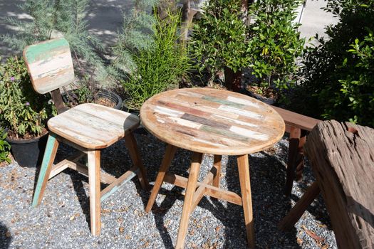 vintage wooden table and Chairs put on backyard tropical garden.