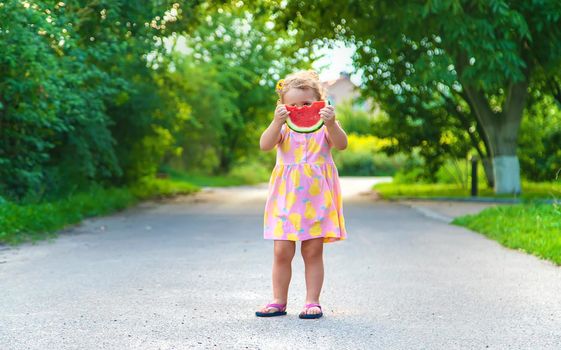 Child girl eats watermelon in summer. Selective focus. food.